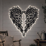 Black metal Heart Angel wings wall art with Soft White LED Lighting displayed on the wall