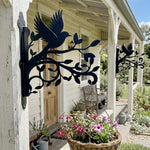 Hummingbird flying on branch metal hanging basket bracket mounted on outdoor wall for plant decoration