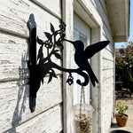 Hummingbird with honeysuckle metal hanging basket bracket mounted on outdoor wall for plant decoration