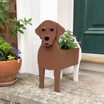 Labrador dog planter filled with fresh flowers is placed in the garden