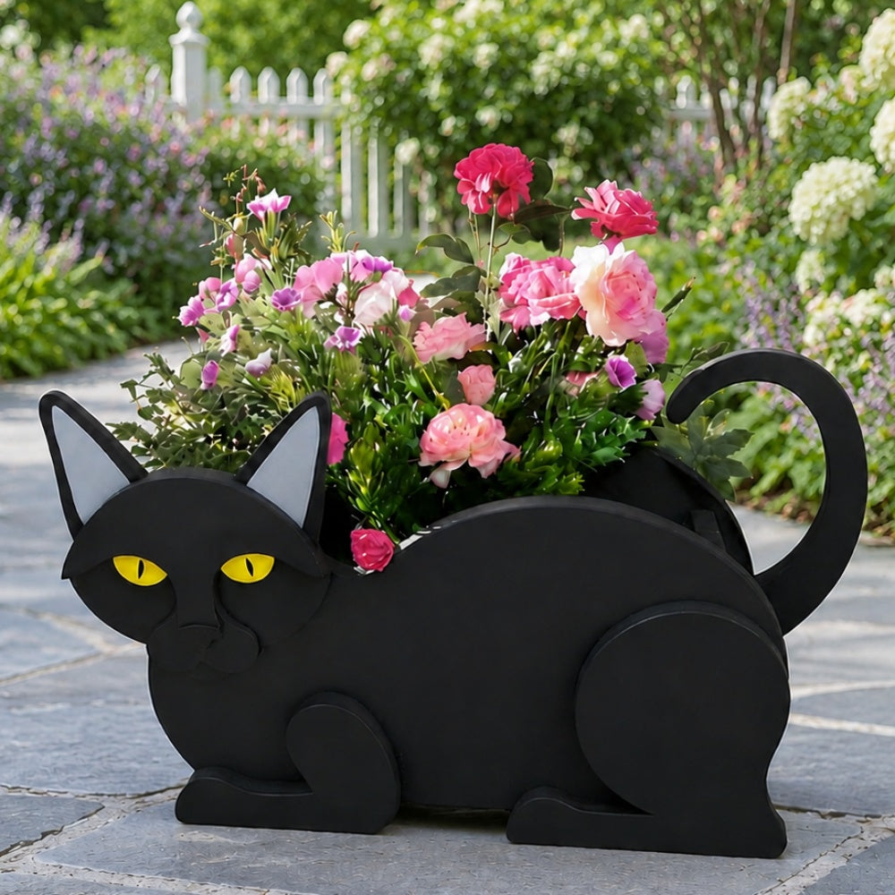 Lying cats planter filled with fresh flowers is placed in the garden