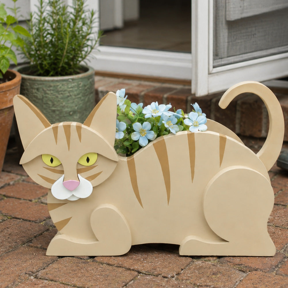 Lying cats planter filled with fresh flowers is placed in the garden