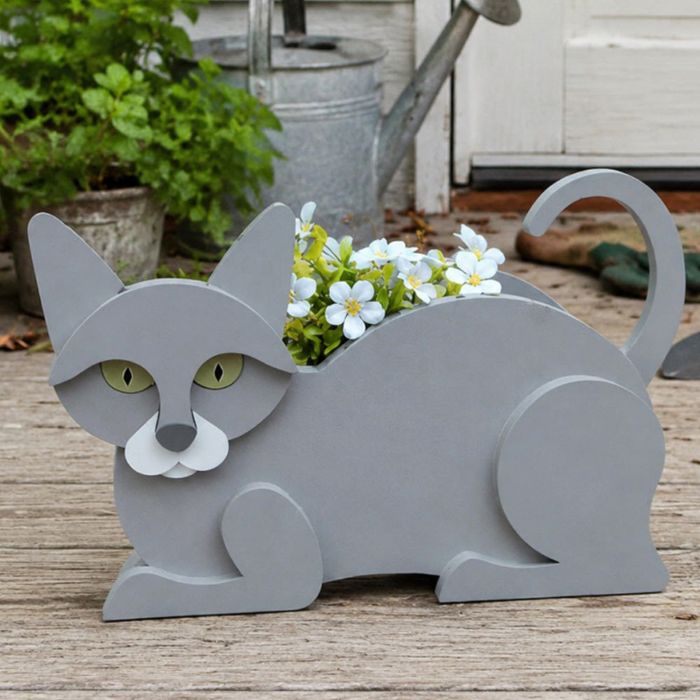 Lying cats planter filled with fresh flowers is placed in the garden