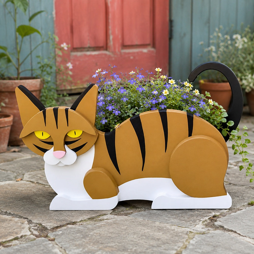 Lying cats planter filled with fresh flowers is placed in the garden