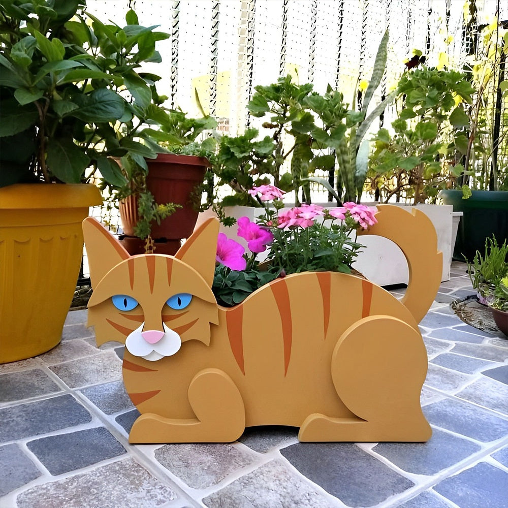 Lying cats planter filled with fresh flowers is placed in the garden