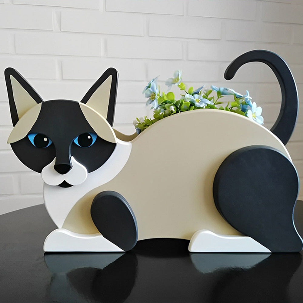 Lying cats planter filled with fresh flowers is placed in the garden
