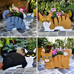 Lying cats planter filled with fresh flowers is placed in the garden