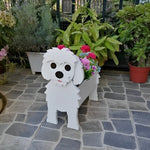 Maltese dog planter filled with fresh flowers is placed in the garden