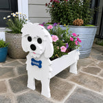 Maltese dog planter filled with fresh flowers is placed in the garden