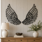 Black Metal Angel Feather Wings Wall Art with Intricate Cutout Details displayed on a beige paneled wall