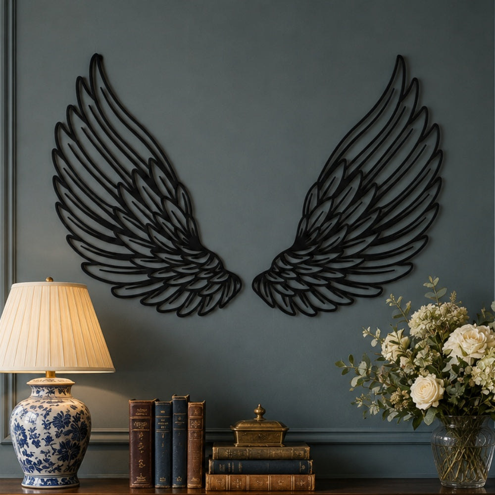 Black metal angel feather wings wall art with intricate cutout details displayed on the wall