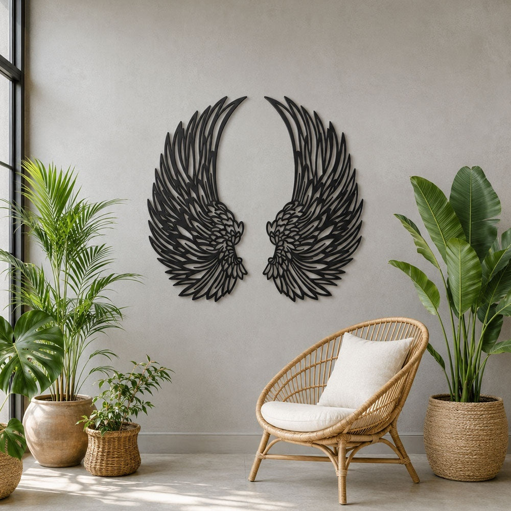 Black metal angel wings wall art displayed on a living room wall