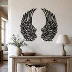 Black metal angel wings wall art displayed on a living room wall