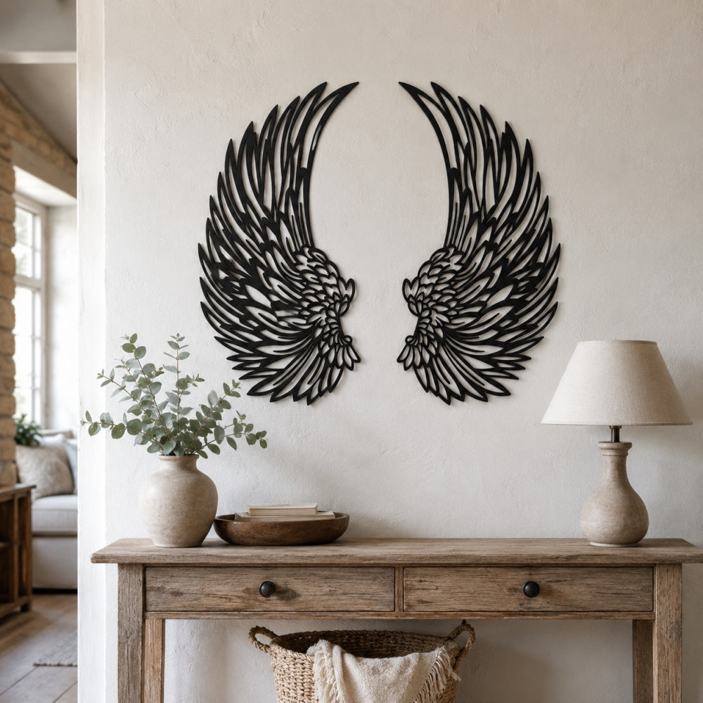 Black metal angel wings wall art displayed on a living room wall