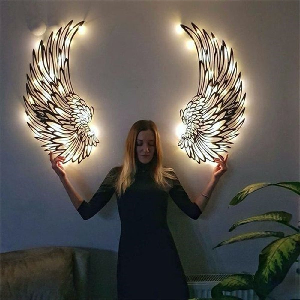 Black metal angel wings wall art displayed on a living room wall