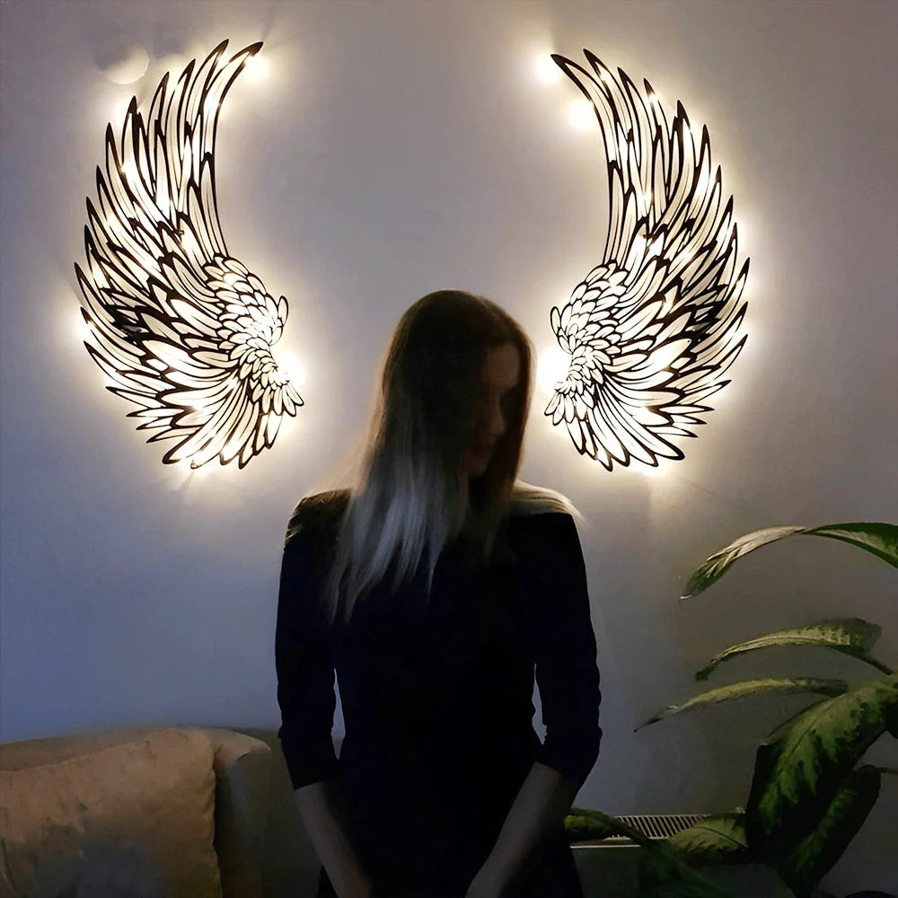 Black metal angel wings wall art displayed on a living room wall