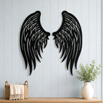 Black metal Angel wings wall art with intricate cutout details displayed on the wall