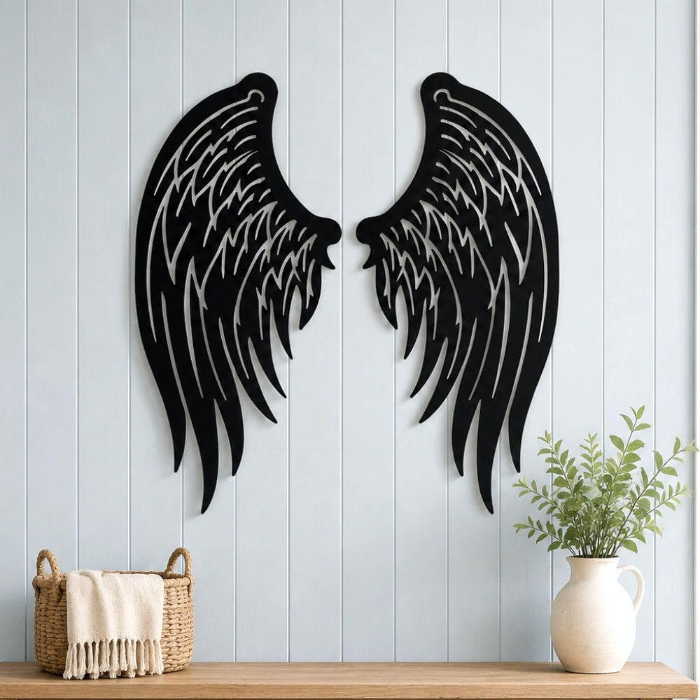Black metal Angel wings wall art with intricate cutout details displayed on the wall