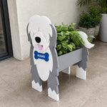 Old English Sheepdog  planter filled with fresh flowers is placed in the garden.
