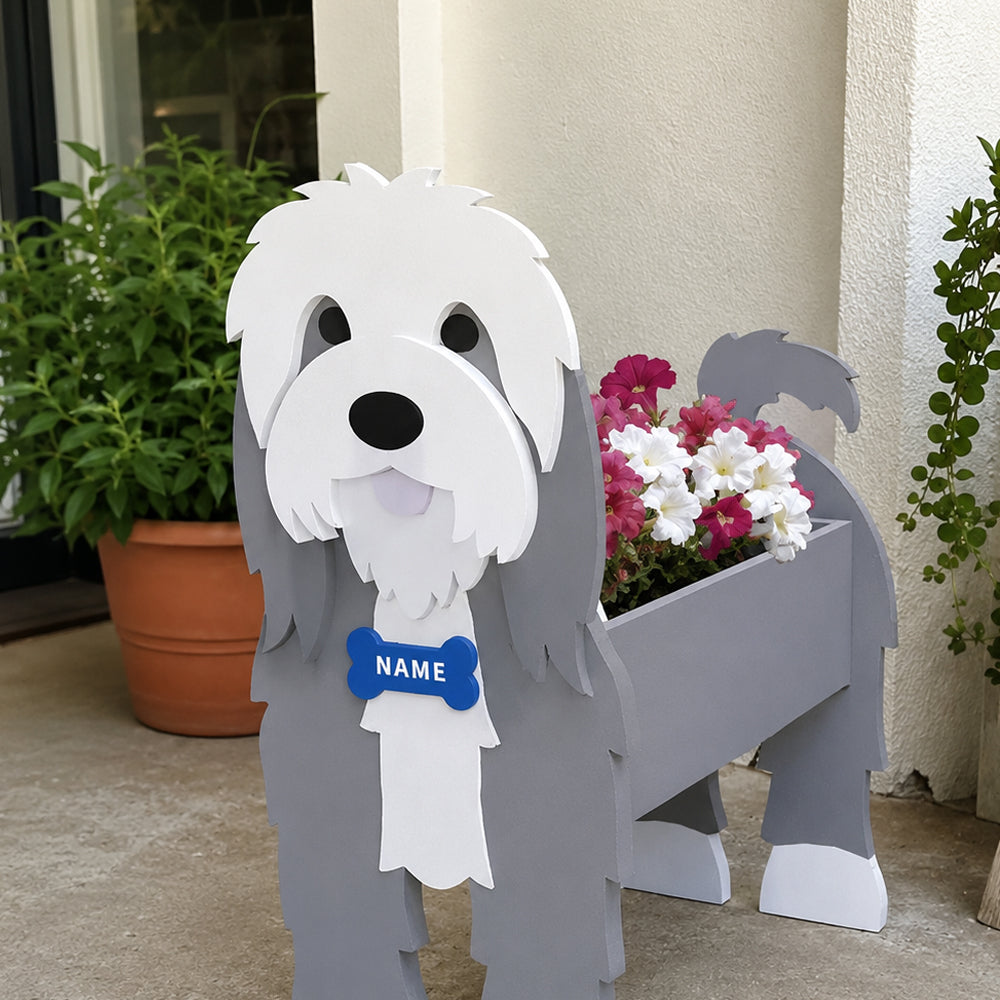 Old English Sheepdog  planter filled with fresh flowers is placed in the garden.