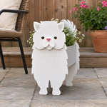 Persian cat planter filled with fresh flowers is placed in the garden