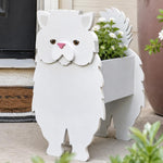 Persian cat planter filled with fresh flowers is placed in the garden