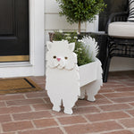 Persian cat planter filled with fresh flowers is placed in the garden