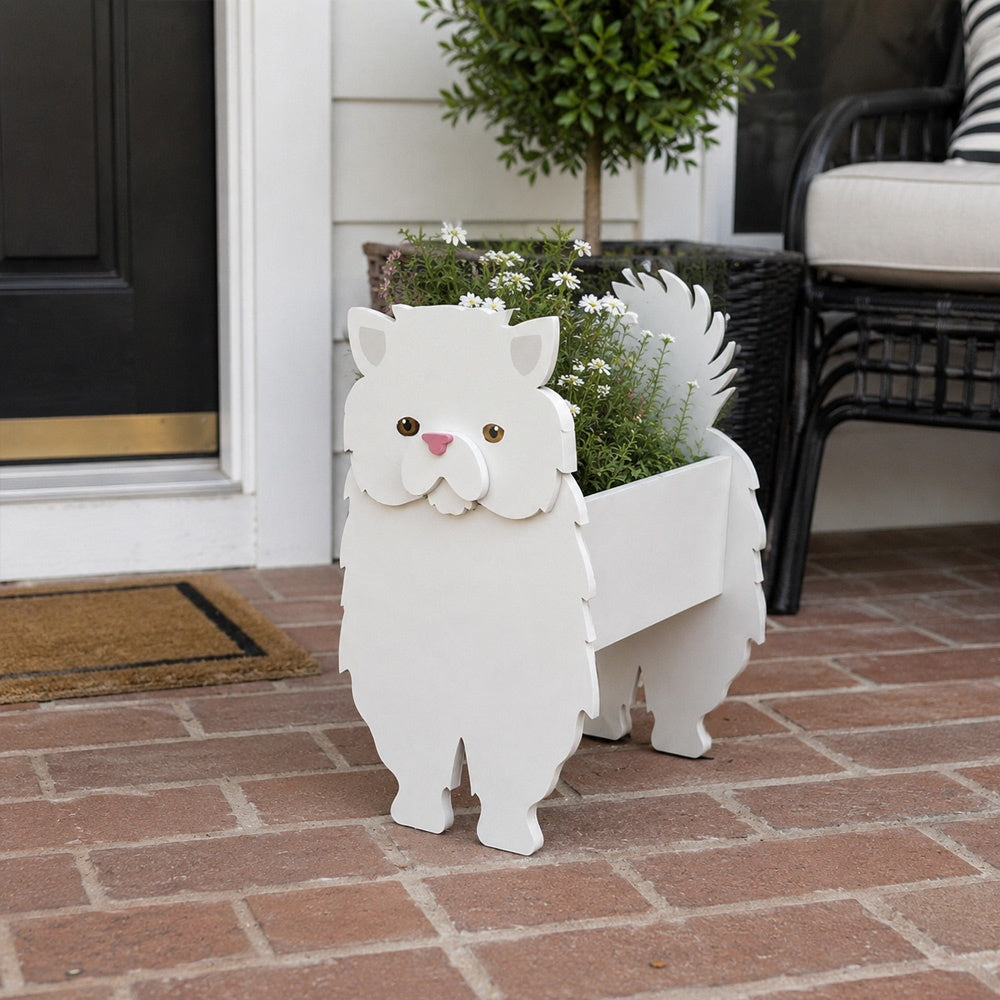 Persian cat planter filled with fresh flowers is placed in the garden