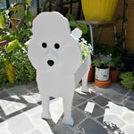 Poodle dog planter filled with fresh flowers is placed in the garden