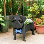 Black pug dog planter with a blue name tag in a garden setting
