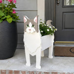 Ragdoll cat planter filled with fresh flowers is placed in the garden