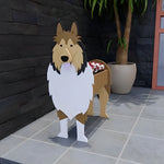 Rough Collie dog planter filled with fresh flowers is placed in the garden