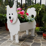 Samoyed dog planter filled with fresh flowers is placed in the garden
