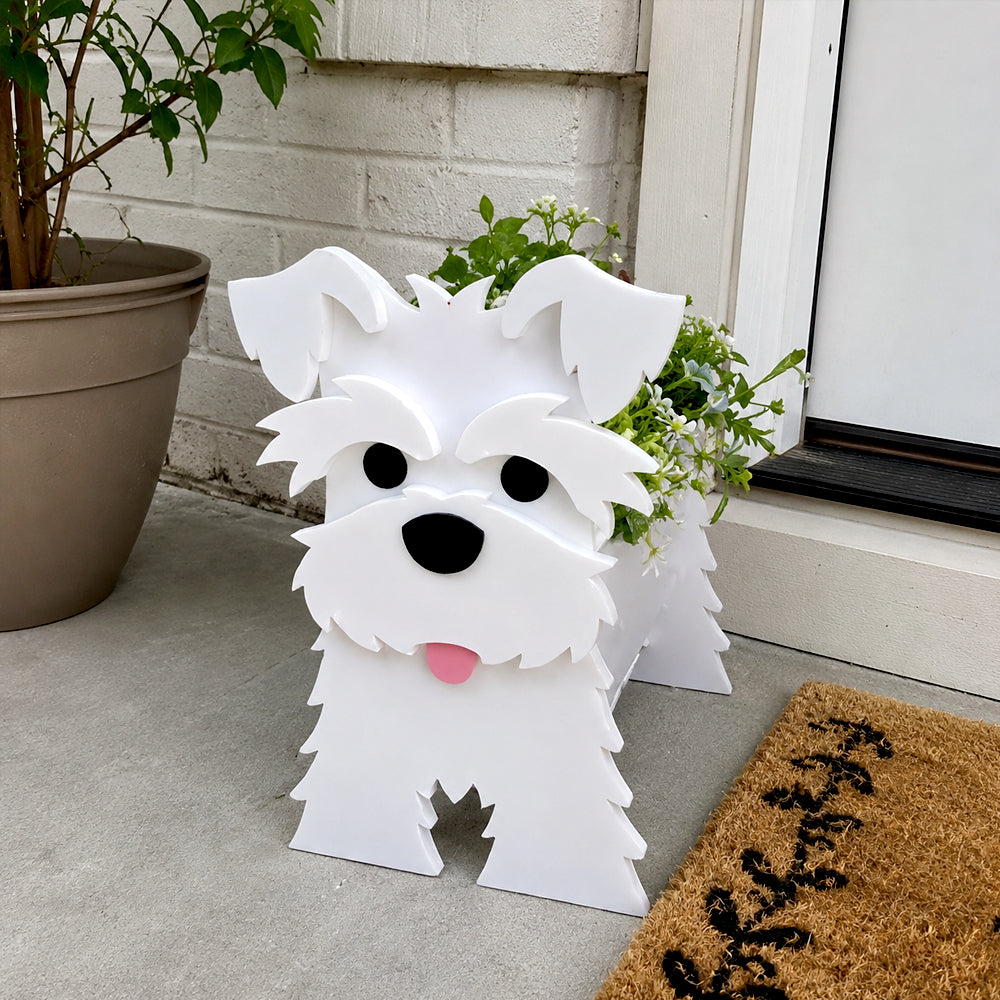 Schnauzer dog planter filled with fresh flowers is placed in the garden