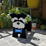 Schnauzer dog planter filled with fresh flowers is placed in the garden