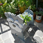 Schnauzer dog planter filled with fresh flowers is placed in the garden