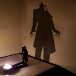 Shadow stalker halloween metal candle holder casting a spooky shadow on the wall