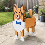 Sheltie-Shetland Sheepdog planter filled with fresh flowers is placed in the garden