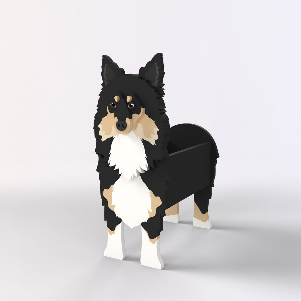 Sheltie-Shetland Sheepdog planter filled with fresh flowers is placed in the garden