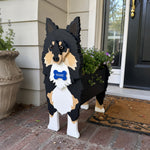 Sheltie-Shetland Sheepdog planter filled with fresh flowers is placed in the garden