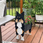 Sheltie-Shetland Sheepdog planter filled with fresh flowers is placed in the garden