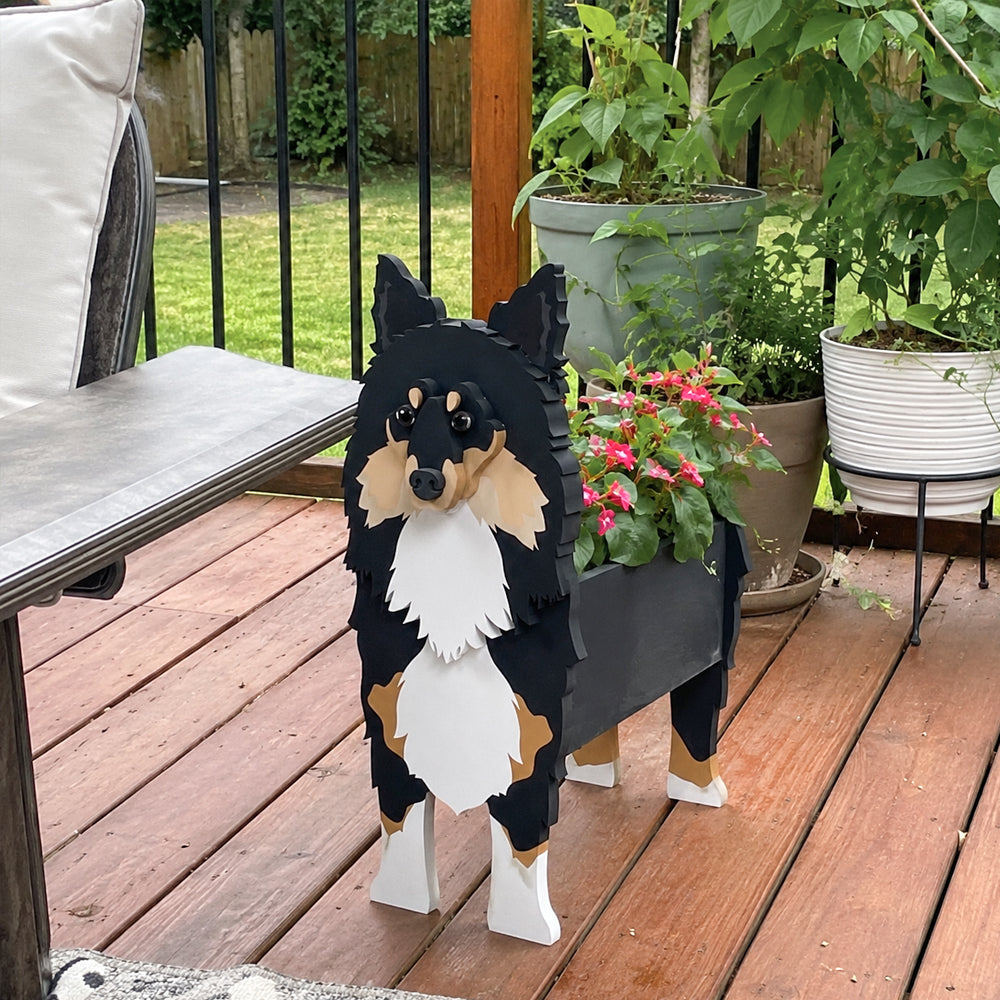 Sheltie-Shetland Sheepdog planter filled with fresh flowers is placed in the garden