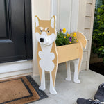 Shiba Inu dog planter filled with fresh flowers is placed in the garden.