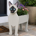 Siamese cat planter filled with fresh flowers is placed in the garden