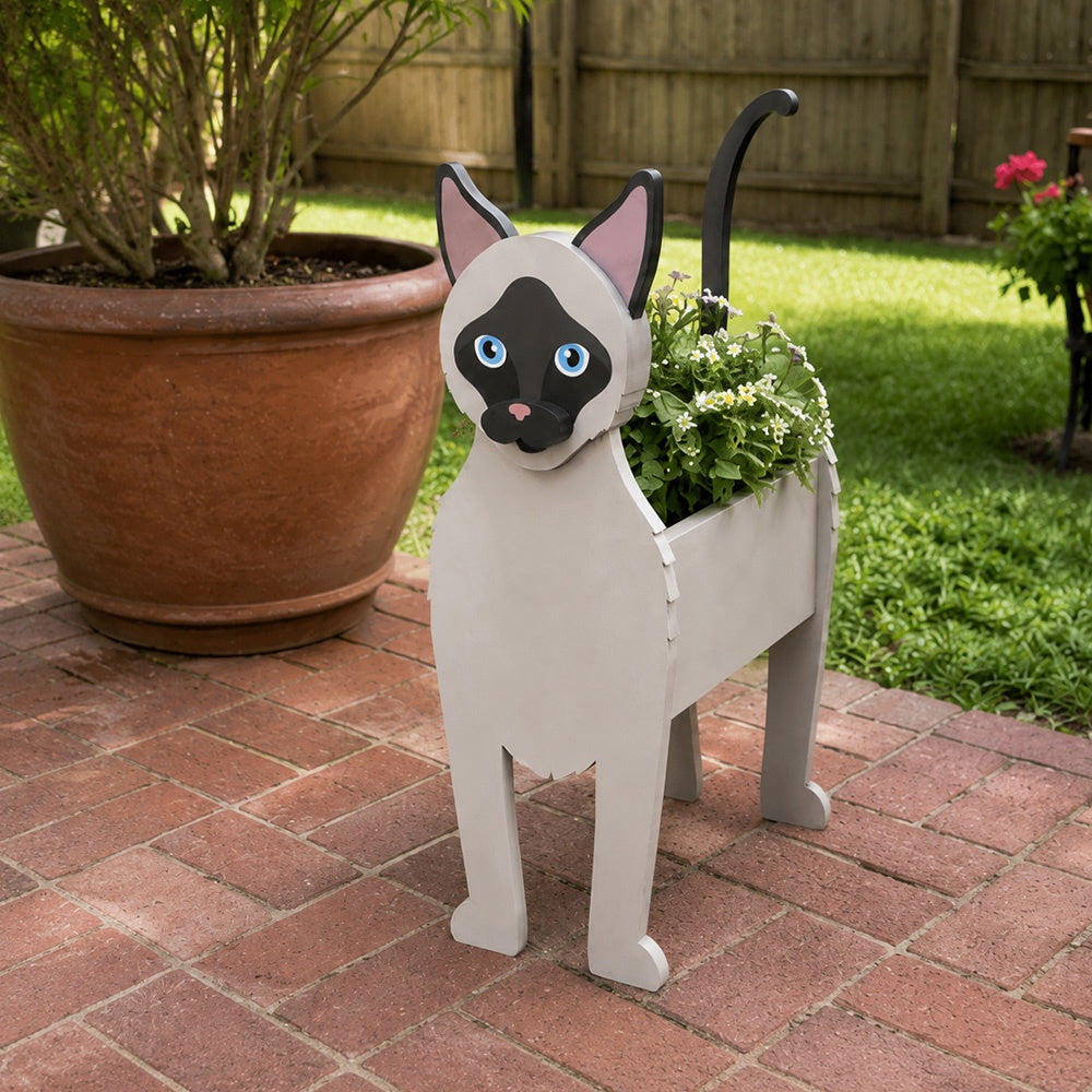 Siamese cat planter filled with fresh flowers is placed in the garden