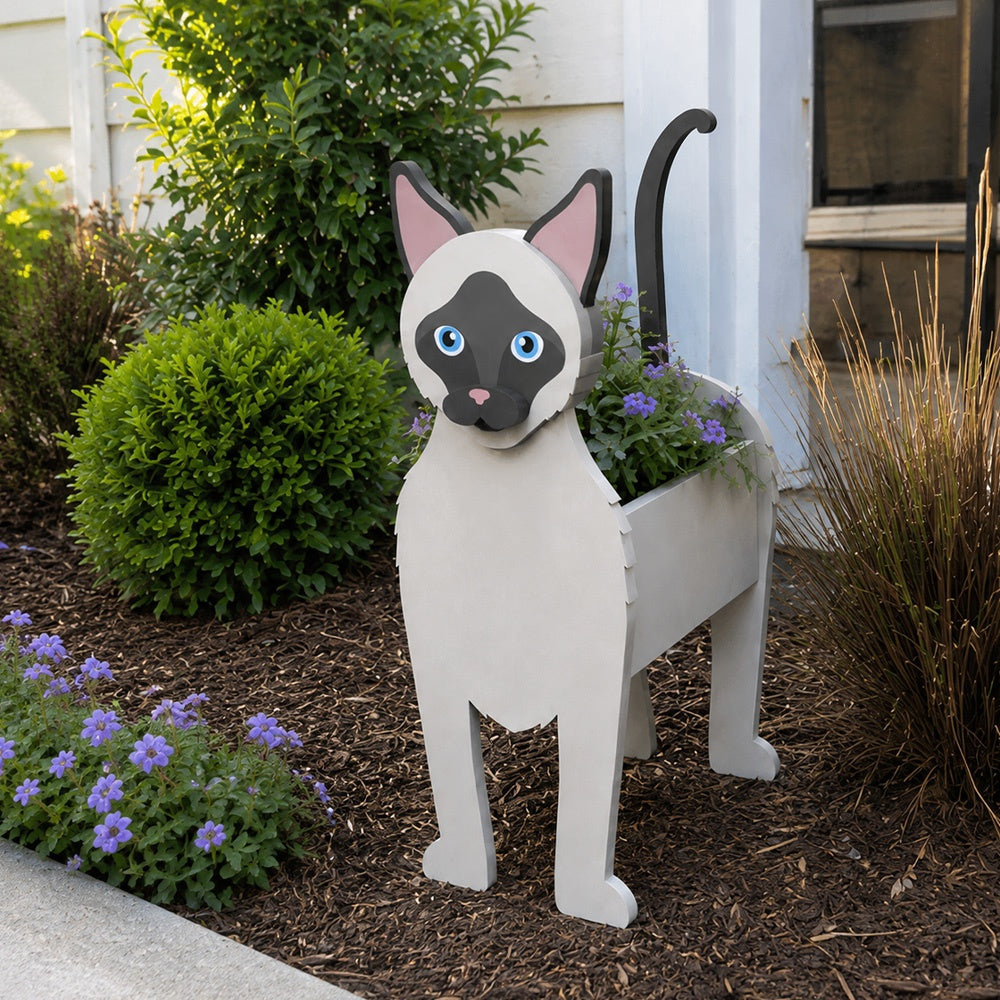 Siamese cat planter filled with fresh flowers is placed in the garden