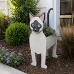 Siamese cat planter filled with fresh flowers is placed in the garden