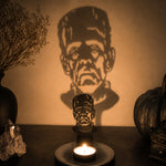Sinister face halloween metal candle holder casting a spooky shadow on the wall