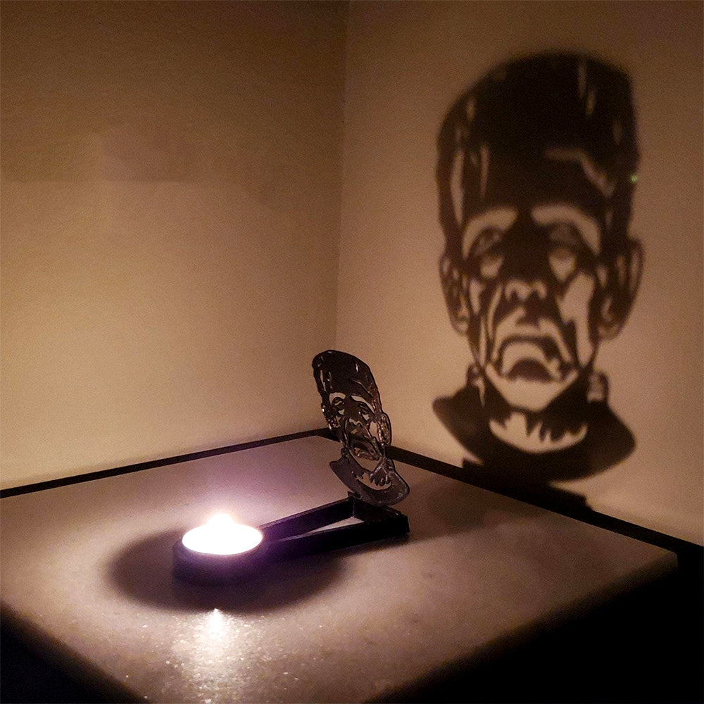Sinister face halloween metal candle holder casting a spooky shadow on the wall
