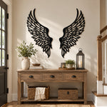 Black metal Soaring Angel Wings wall art with intricate cutout details displayed on the wall